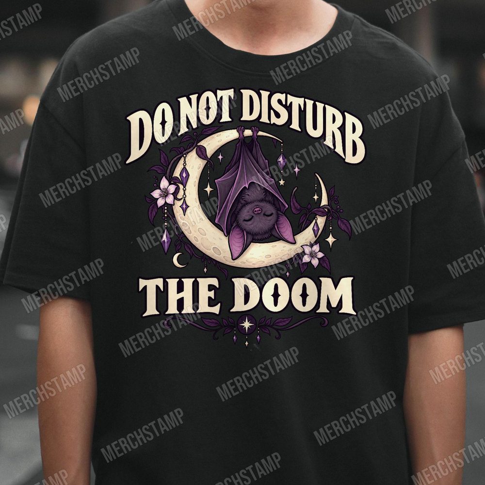Do Not Disturb The Doom PNG design shown on a black t-shirt, a sleeping purple bat hanging from a crescent moon draped in crystals between the words Do Not Disturb The Doom