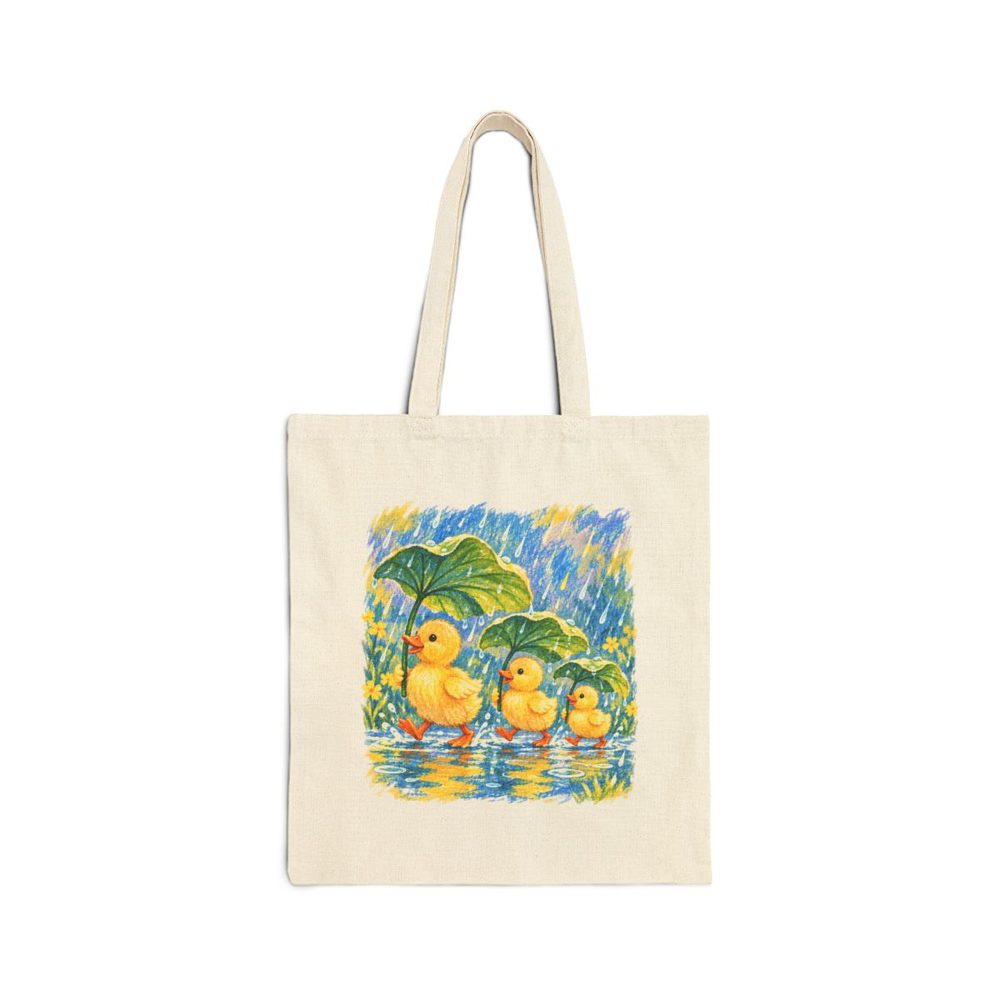 Rainy Day Ducklings tote bag in natural cotton canvas, printed with three yellow ducklings sheltering under big green leaves in the rain